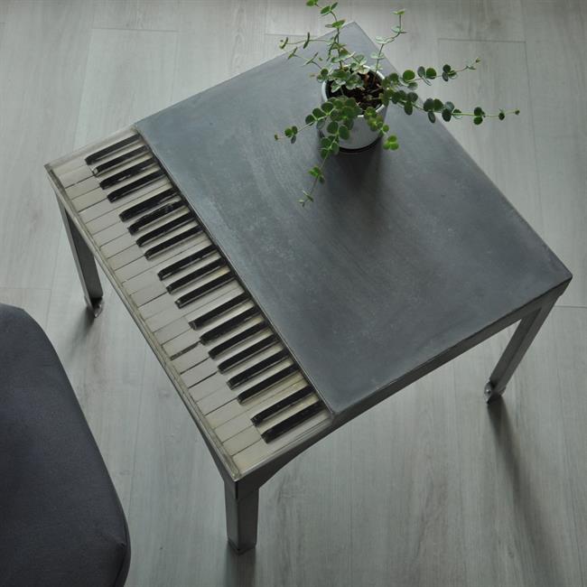  Découvrez cette table basse unique en son genre, combinant la robustesse de l'acier et du béton avec l'élégance de touches de piano incluses dans la résine. Cette création exceptionnelle, idéale pour les amateurs de musique et de design, apporte une touche artistique et sophistiquée à n'importe quel espace de vie. Parfaitement adaptée pour être le centre d'attention de votre salon, cette table basse est à la fois fonctionnelle et décorative. Elle offre un espace généreux pour vos objets quotidiens tout en étant une pièce maîtresse conversationnelle. Transformez votre intérieur avec cette fusion innovante de style et de fonctionnalité.